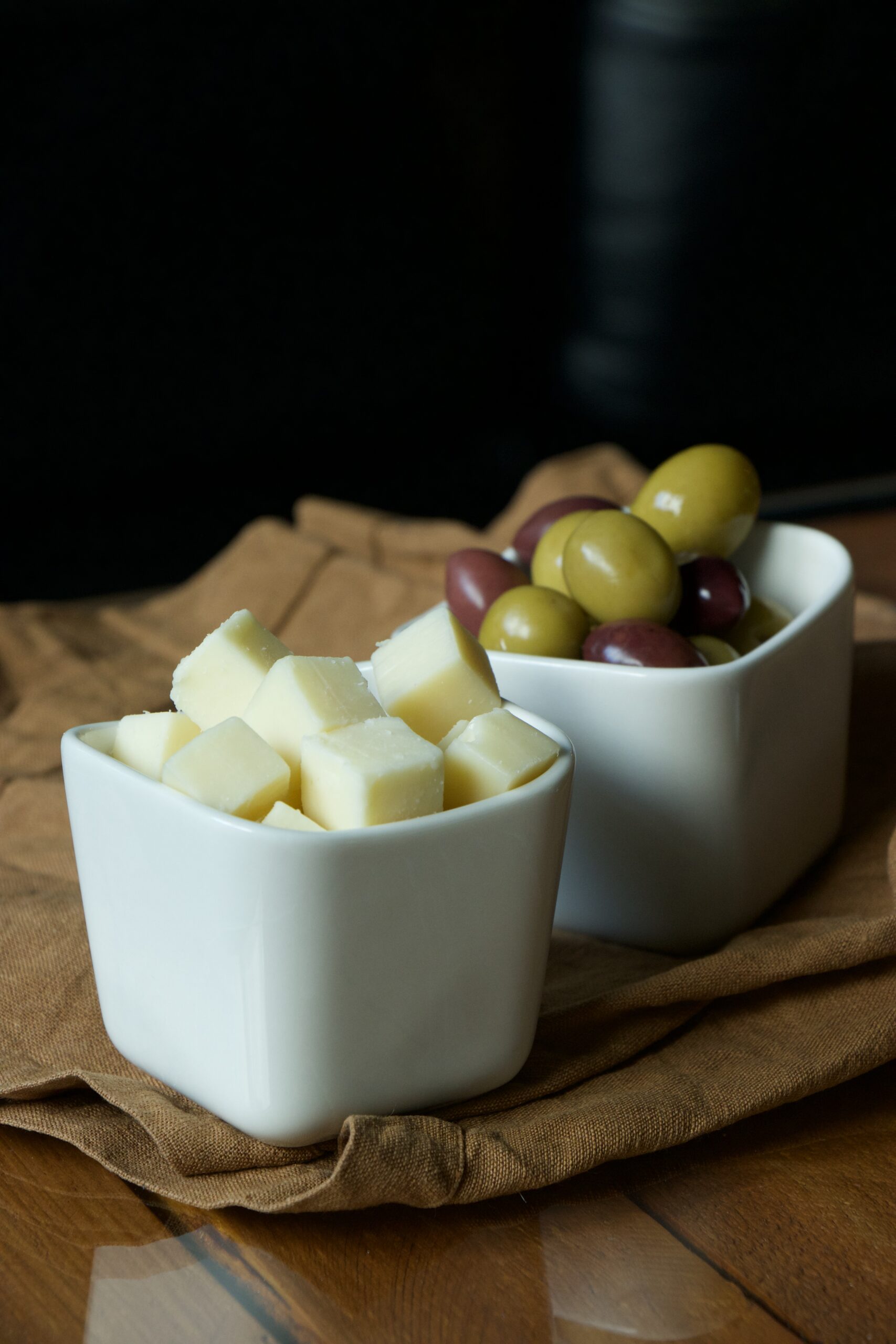 In zwei Schalen liegen Käse und Oliven als Snack
